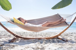 Brunette relaxing in the hammock at the beach